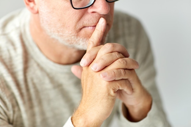 old age, problem and people concept - close up of senior man in glasses thinking