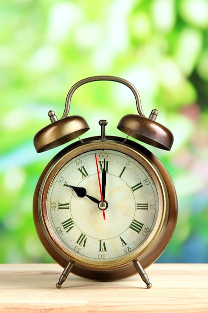 Old alarm clock on bright background