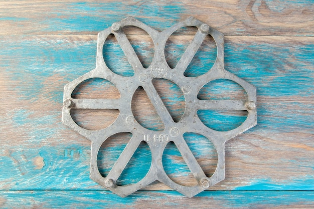 Old aluminum dumplings mold on blue wooden background. Copy space for text.