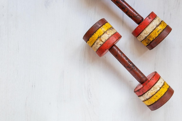 Old ancient dumbbells on white wooden background