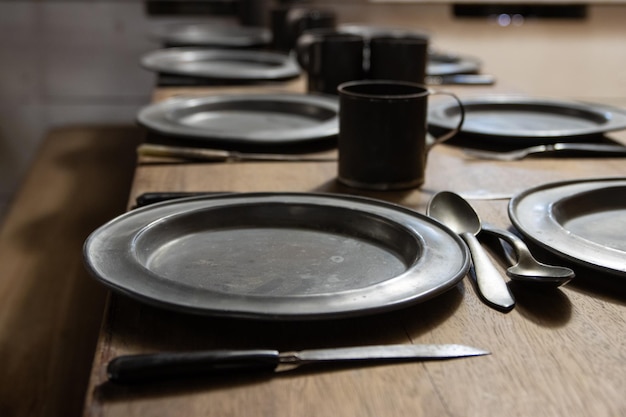 Old antique dishes  metal retro plates and knifes on the table  battleship