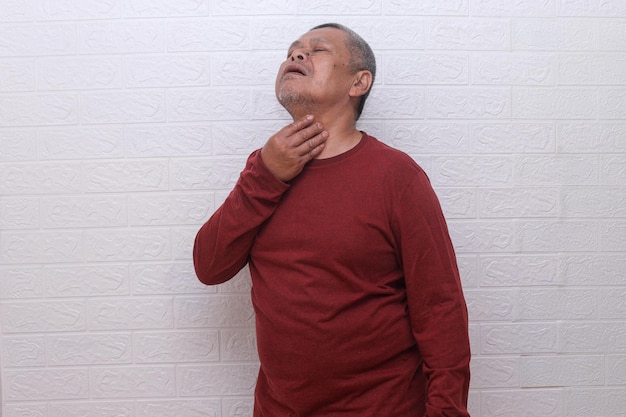 Old Asian man feeling painful in the throat