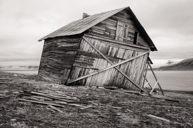 Photo old barn on field against sky svalbard coast