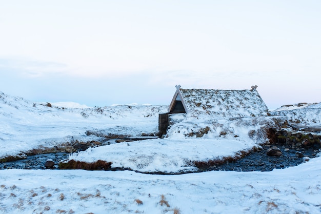 An old bathhouse with a hot spring in the mountains of Iceland.