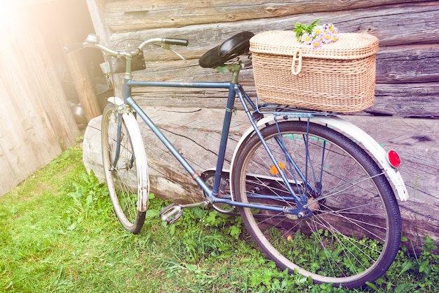 An old bicycle with a basket of flowers in the garden in the village