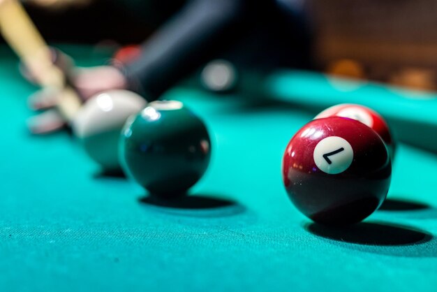 Old billiard ball and stick cue on a green table