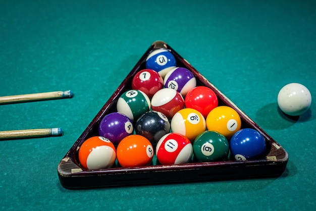 Old billiard ball and stick cue on a green table