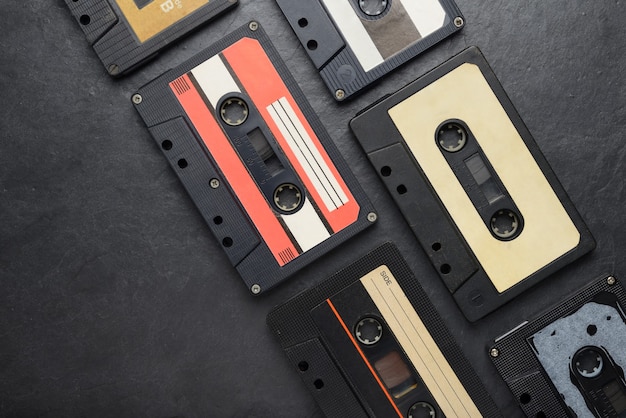 Old black audio tape compact cassettes on black slate background