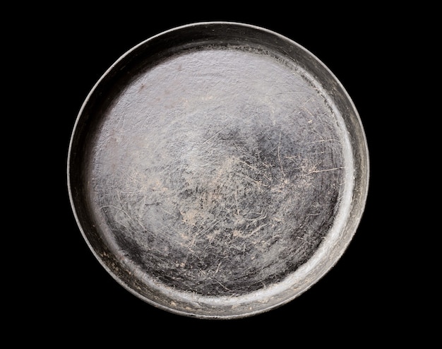 Old black cast iron Frying pan isolated on black background