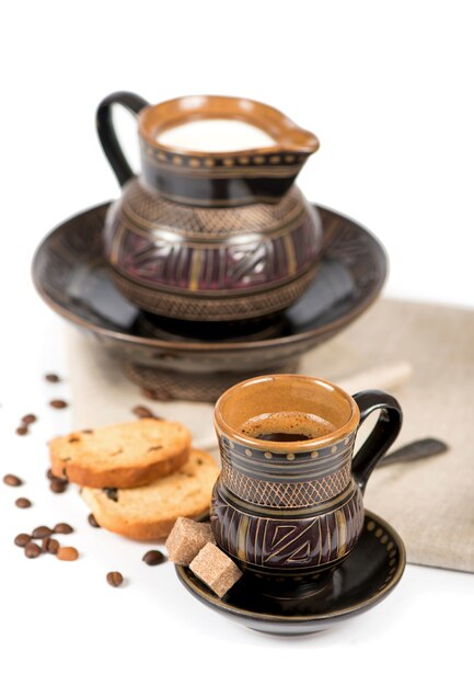 Old black pottery, coffee beans, candy and a cup of drink