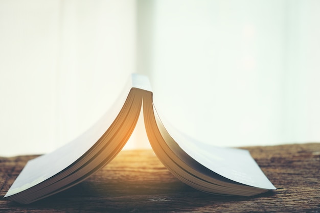 Old books in the light stack on old wooden table interior