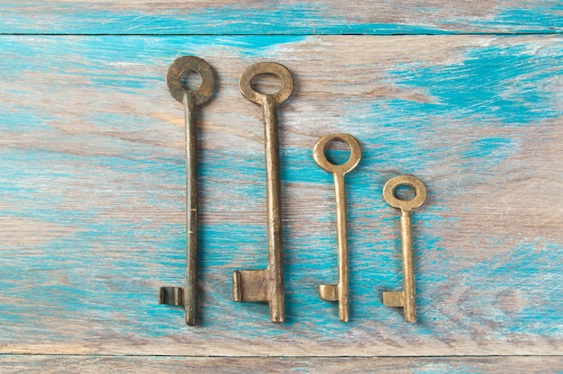 Old brass keys, detail of a classic metal keys on wooden background. Copy space for text