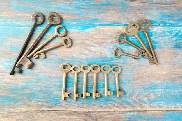 Old brass keys, detail of a classic metal keys on wooden background. Copy space for text`