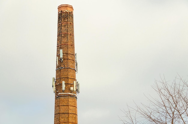 An old brick pipe with cellular communication antennas.