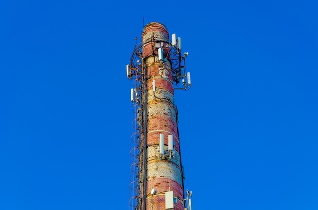 An old brick pipe with cellular communication antennas.