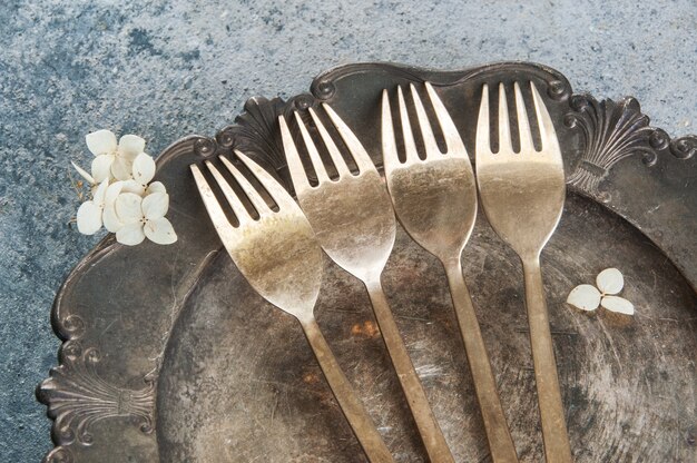 Old bronze forks on a vintage plate