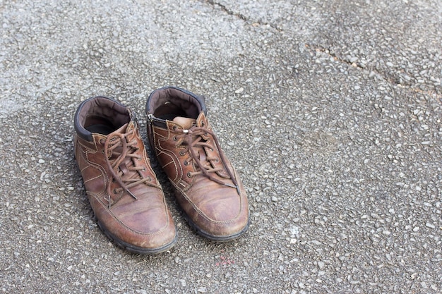 Old brown leather shoes on cement floor