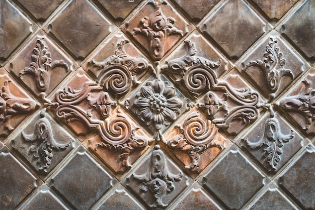 Old brown terracotta tiles decorated with floral motifs