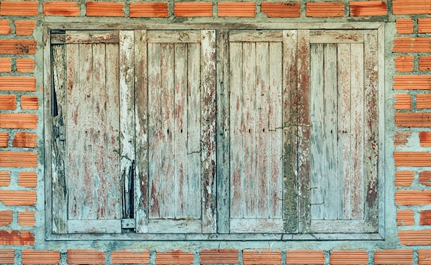 old brown wooden window with brown wall bricks