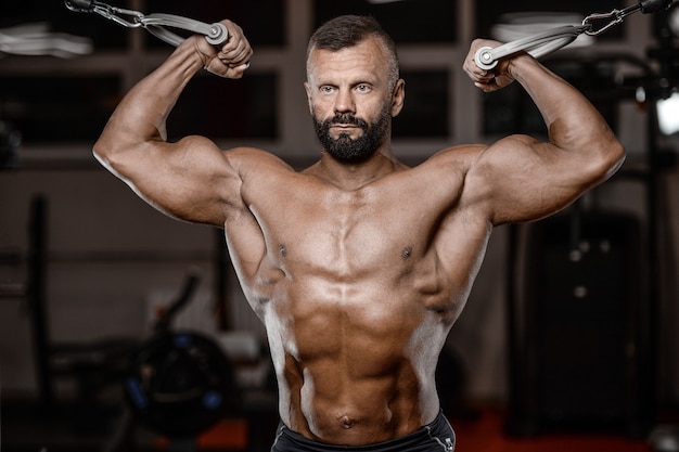 Old brutal strong bodybuilder athletic men pumping up muscles with dumbbells