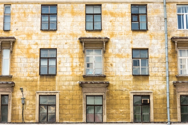 Old building requiring repair in bad condition windows and balconies.