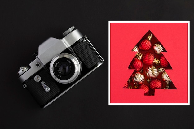 Old camera and Christmas tree on the black background Top view Closeup