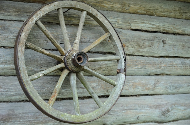 an old cart wheel is hanging on the wall