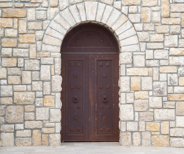 Old castle stone wall with closed big metal doors Vintage gates Retro doors Ancient concept