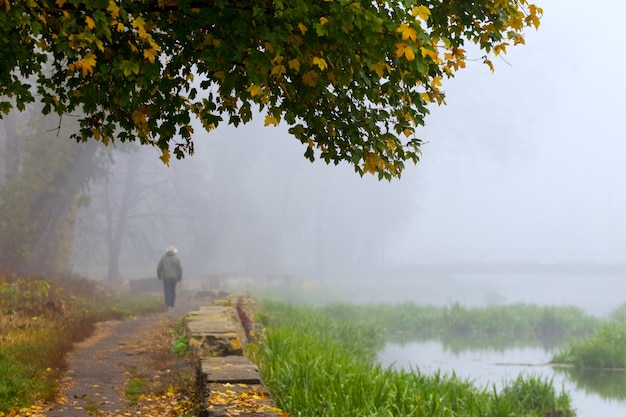 Old city park in autumn, man walking in park_