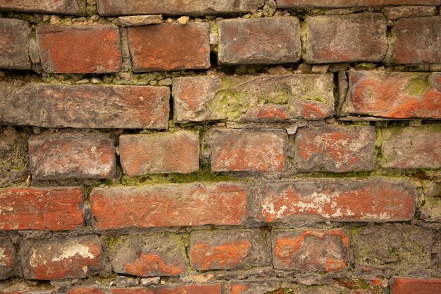 The old city wall is made of red brick with relief