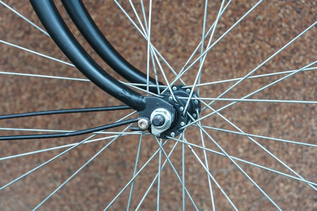 An old classic bike on a wall background Bicycle repair A black bicycle after restoration Details of the bike in closeup