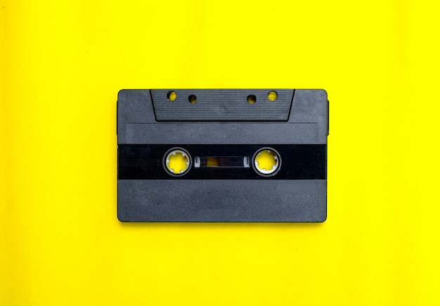 Old compact cassette tape on yellow background