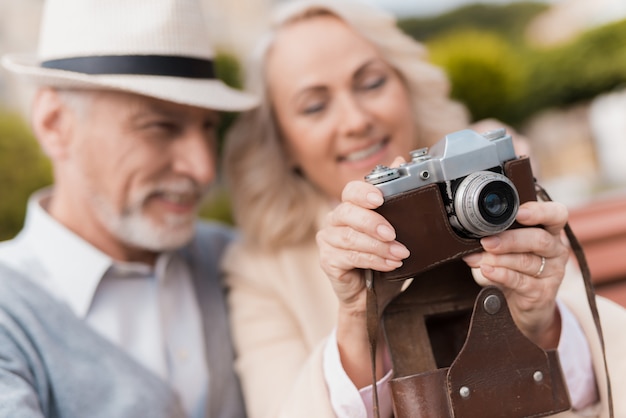 Old Couple Hugs. Woman Hold Vintage Camera.