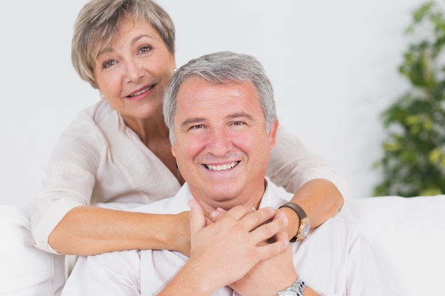 Old couple smiling at the camera and hugging