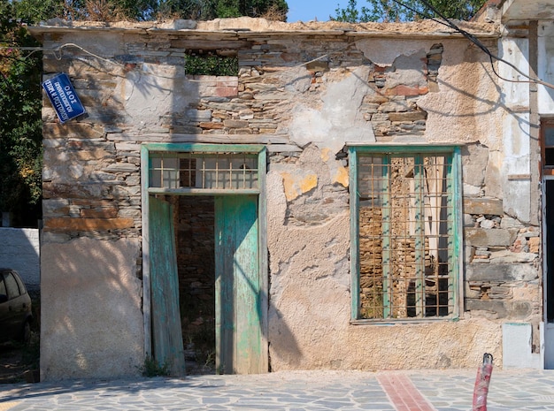 Old crumbling houses on the waterfront of a Greek resort town on the Aegean sea