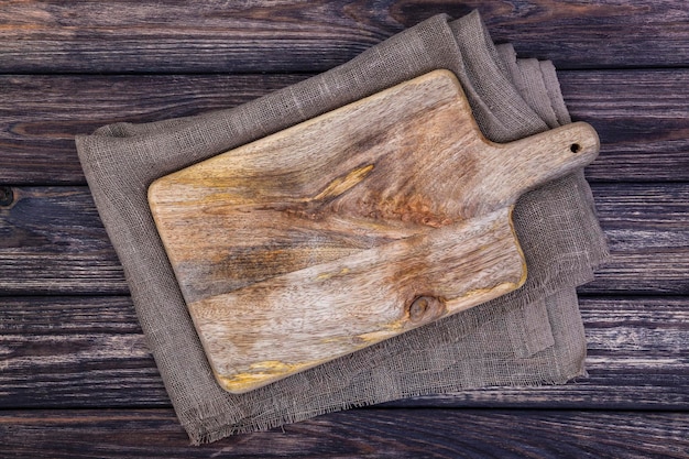 Old cutting board on dark wooden table Top view Copy space