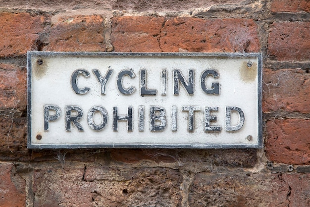 Old Cycling Prohibited Sign on Brick Wall