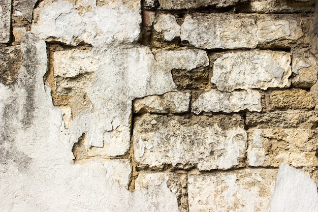 Old damaged brick wall with plaster. Background and textures.