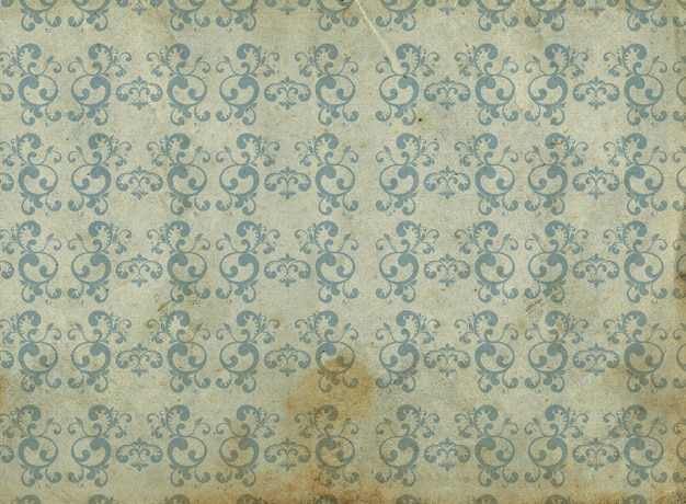 Old and dirty wallpaper with blue arabesques and yellow and orange background