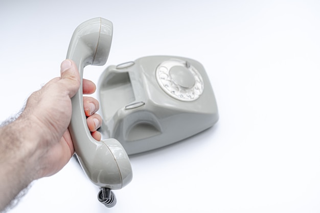 Old disk telephone on a white