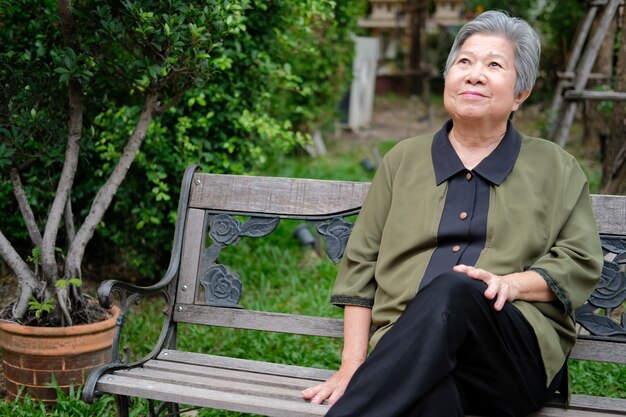 Old elder woman resting in park. elderly female relaxing outdoors. senior leisure lifestyle