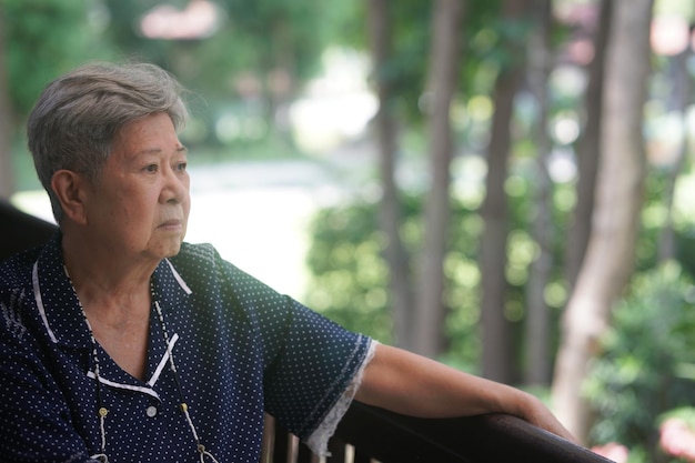 Old elderly elder senior woman resting relaxing on balcony