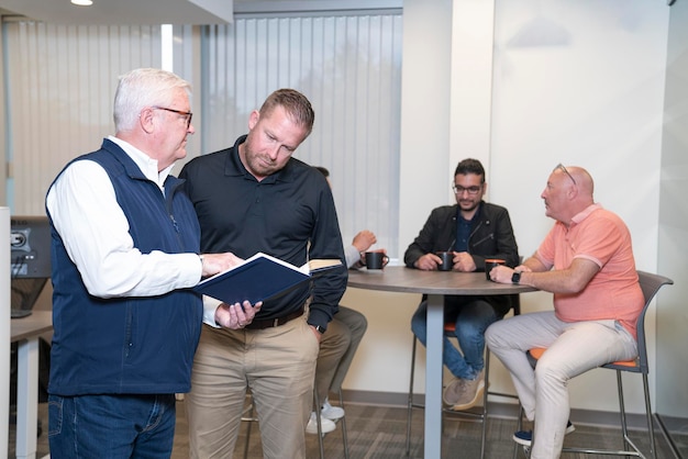 Old Employee explaining his ideas to colleague in standing