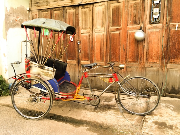 Old fashioned tricycle parking in front of the Dilapidated door.