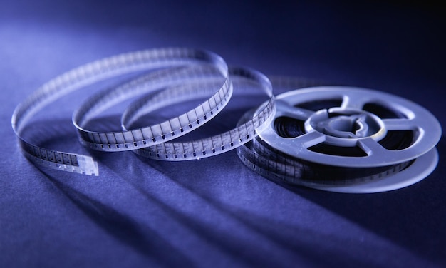 Photo an old film reel sits on a blue background with the word movie