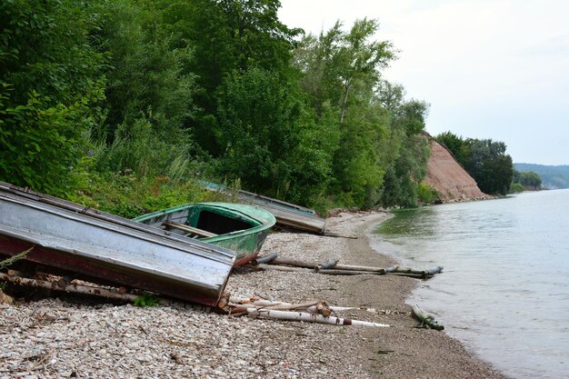 old fishing boats on the bank of the river in cloudy day, close-up