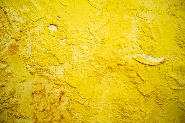 Old flaky yellow paint on the wall Texture Background