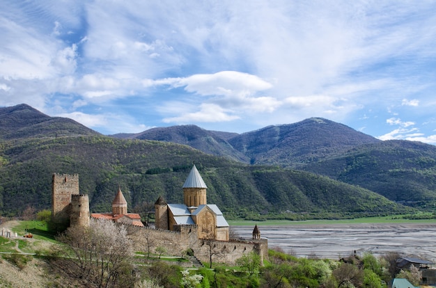 Old fortress on the shore against the backdrop of the mountains