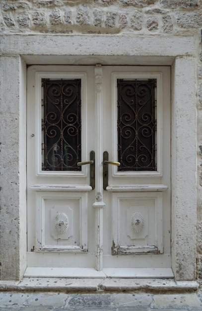 Old glass paneled white wooden door in the old building closeup