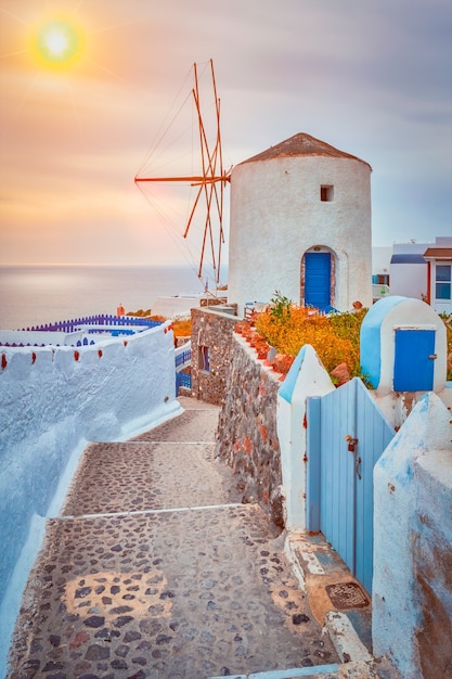 Old greek windmill on santorini island in oia town with stairs in street santorini greece